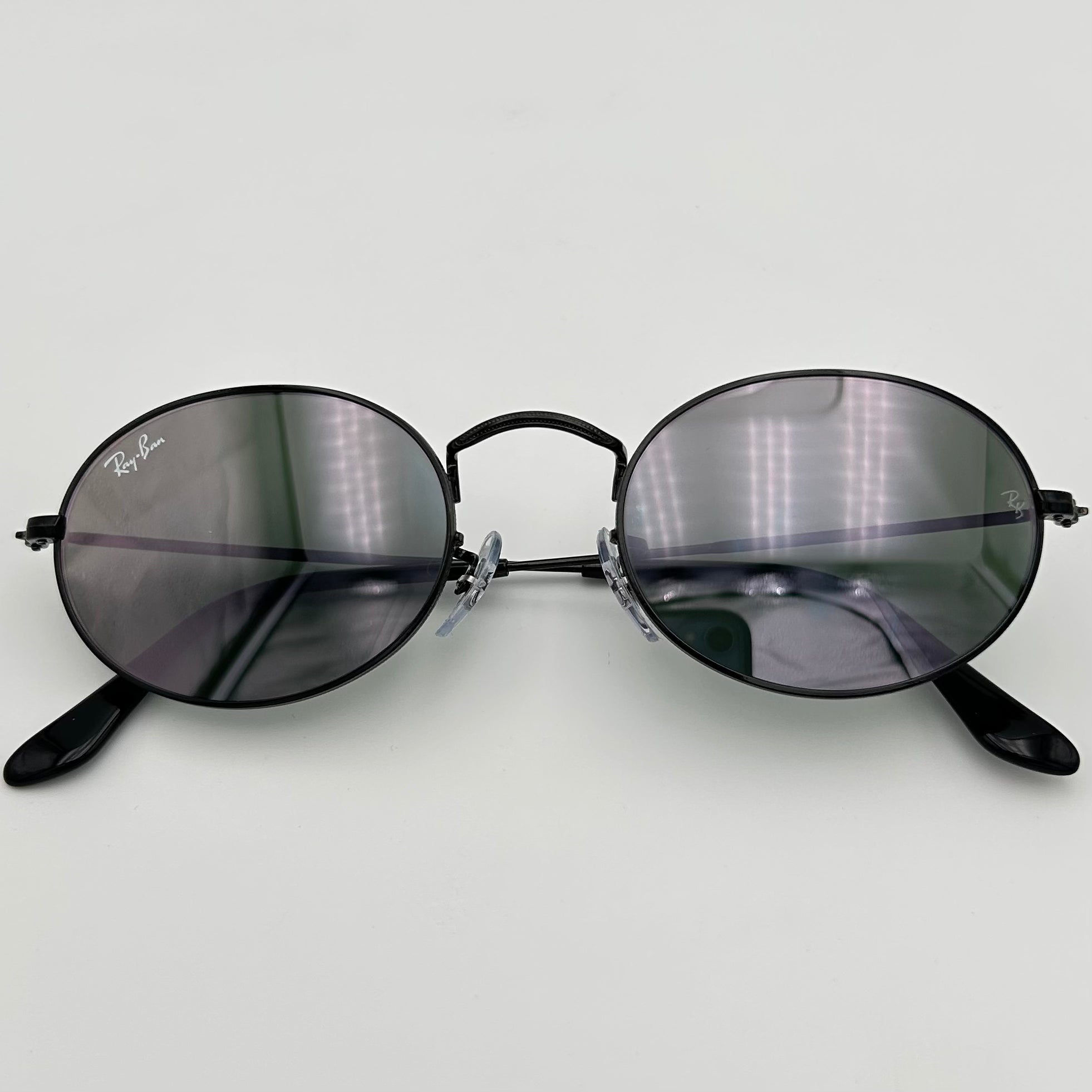 Lunettes de soleil Ray-Ban RB3547N vues du dessus, verres gris aux reflets miroir bronze et monture noire.